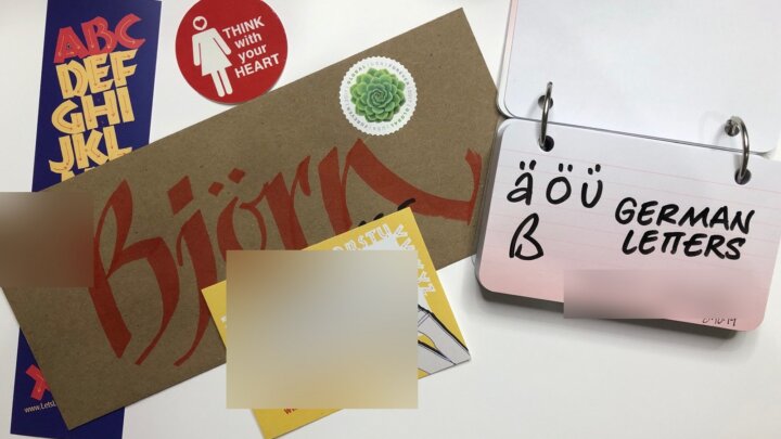Alphabet cards, stickers, and a ring-bound card showing German characters