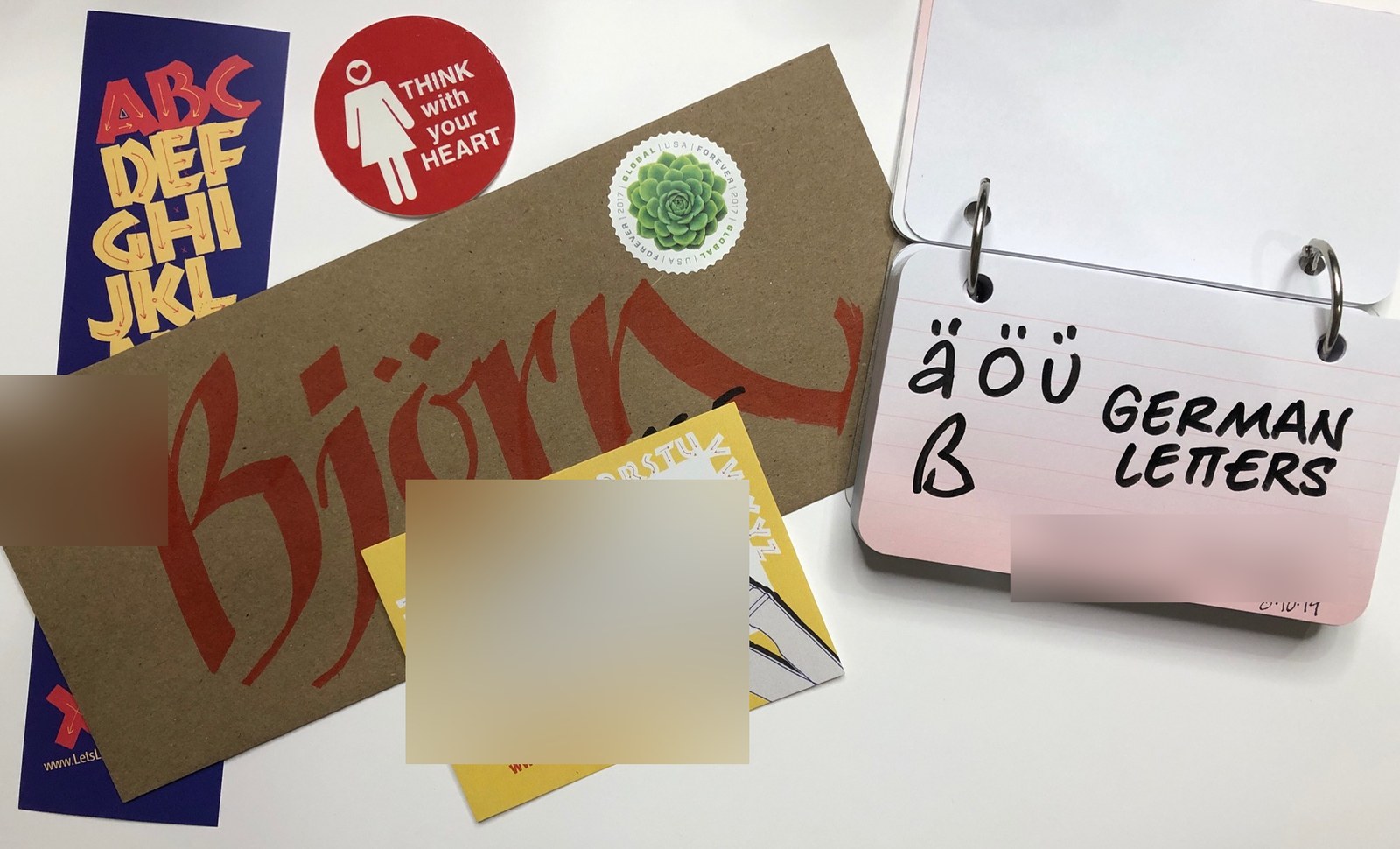 Alphabet cards, stickers, and a ring-bound card showing German characters