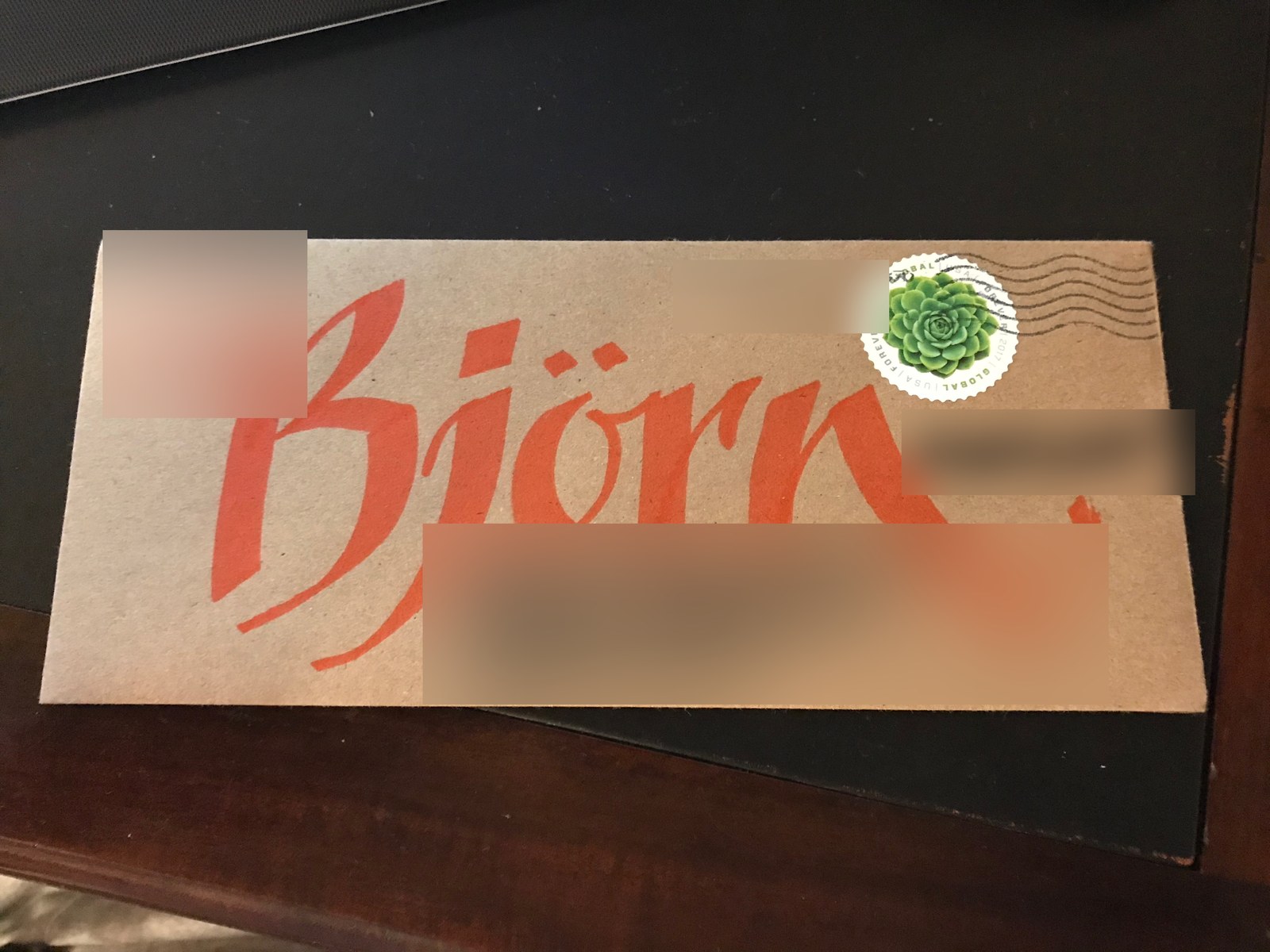 Large red hand lettering on a brown envelope