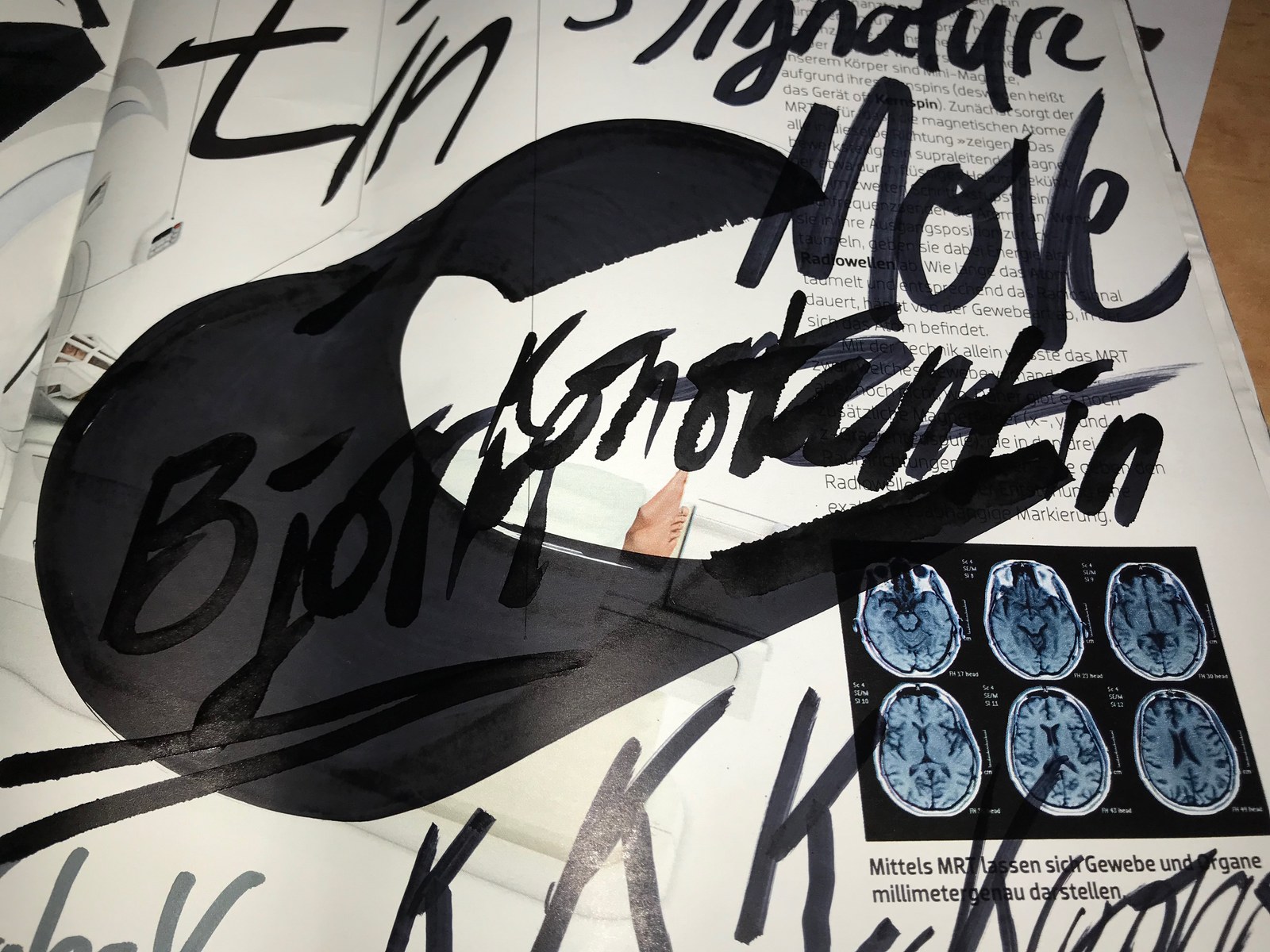 Dark lettering and overlapping strokes from MOLOTOW marker experiments across a printed magazine page.