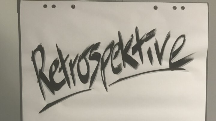 Expressive black retrospective lettering on a blank flipchart