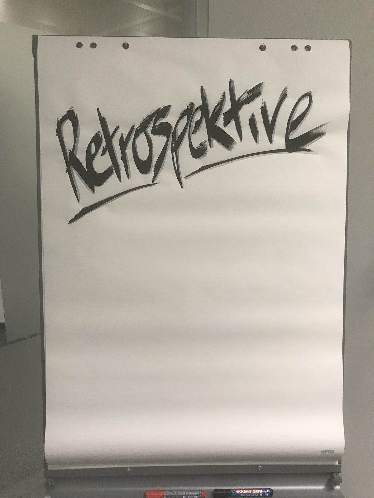 Expressive black retrospective lettering on a blank flipchart